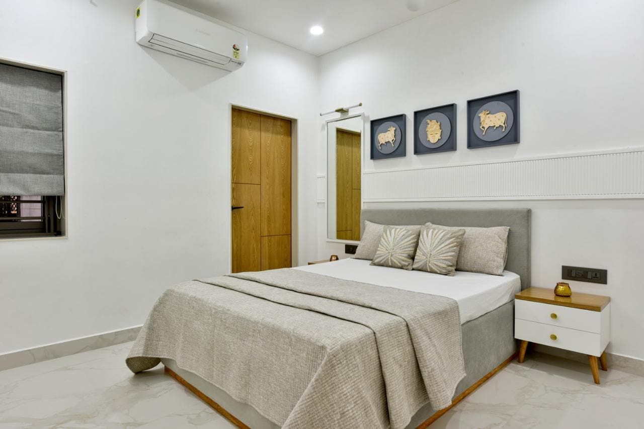 Master bedroom with wide grey upholstered headboard