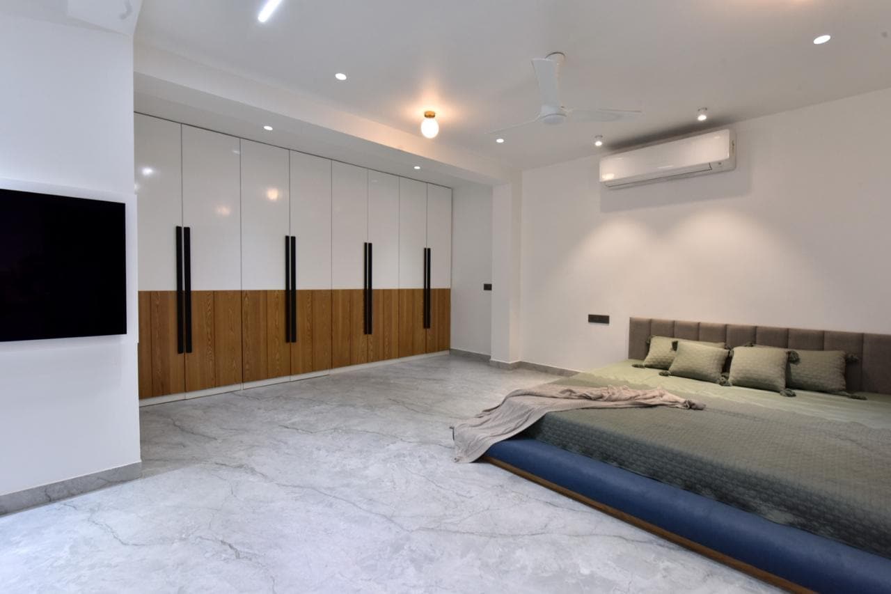 Low platform bed against white and wood wardrobe wall