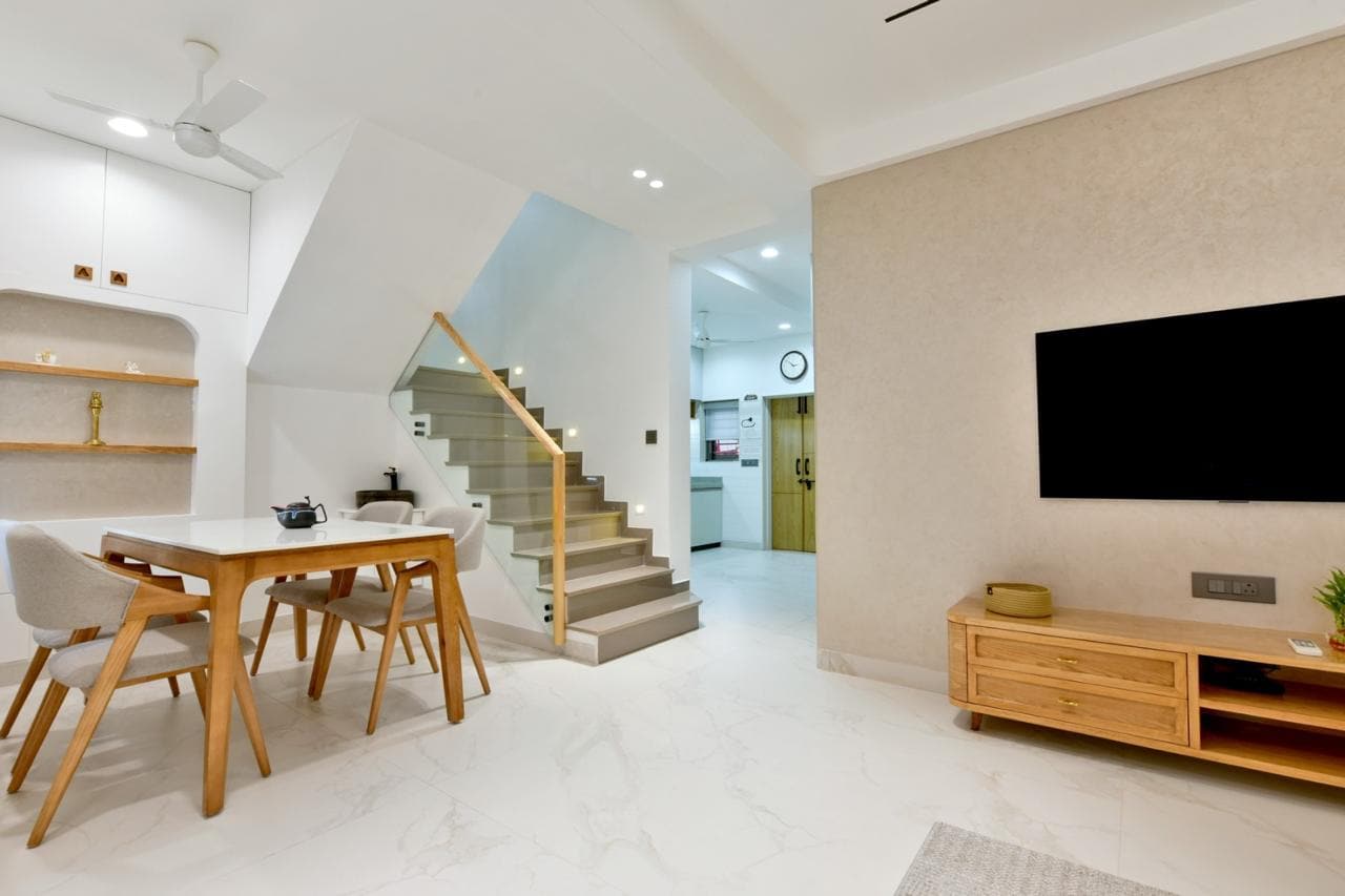Duplex living and dining area with staircase, designed by Jay Ambe Furniture