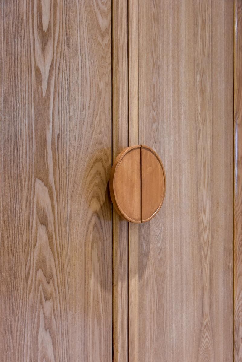 Close-up of a hand-finished teak wardrobe handle