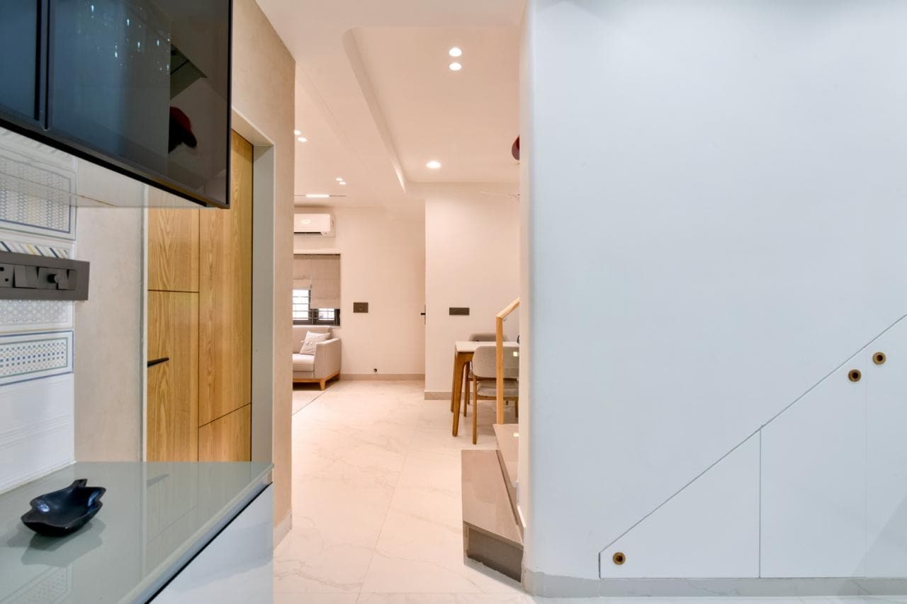 White kitchen corridor with wooden door