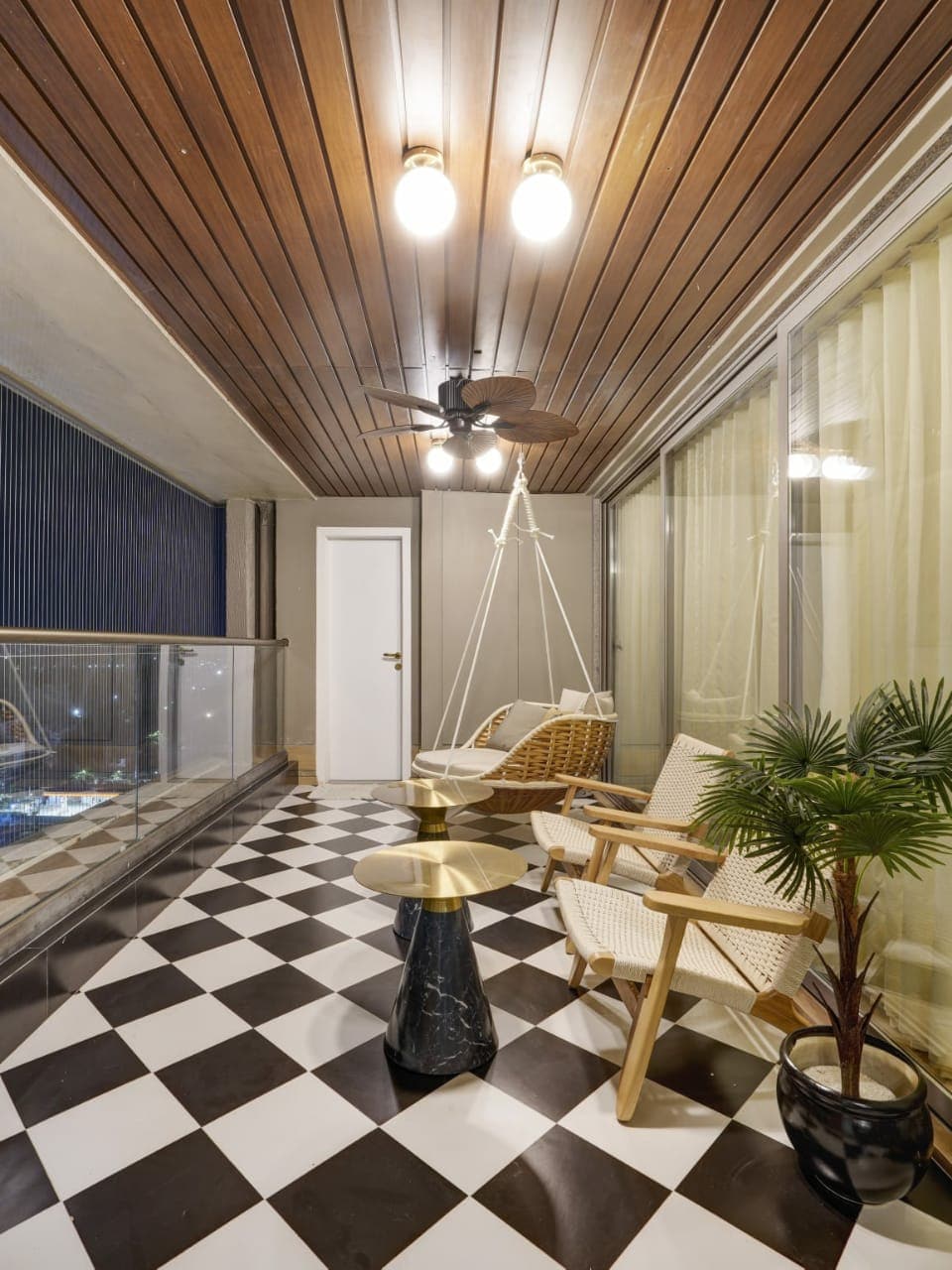 Balcony at night with hanging swing chair and chequered floor