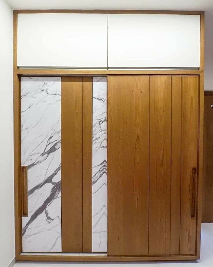 Marble-finish sliding wardrobe panels framed in wood