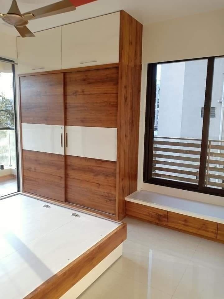 Wood-grain sliding wardrobe beside sunlit window seat